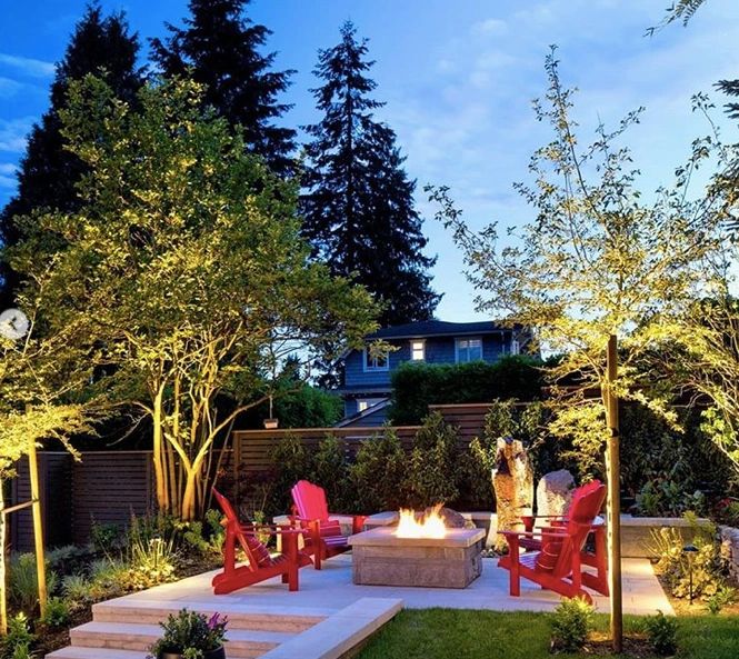 Residential garden and fire pit illuminated with landscape lighting